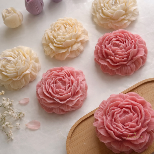 Decorative flowers made of soy wax on a white surface with a wooden board.