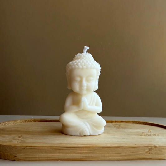 Buddha-shaped candle on a wooden surface with a plain background.Baby Buddha sculptural soy wax candle designed for meditation, calm décor, and mindful gifting

