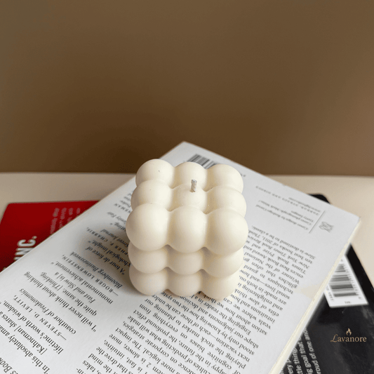 White textured candle on an open book with a blurred background, Bubble sculptural soy wax candle designed for modern décor and thoughtful gifting