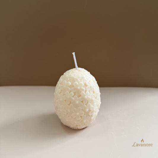 Egg-shaped candle with textured surface on a plain background, featuring the brand 'Lavanore'.