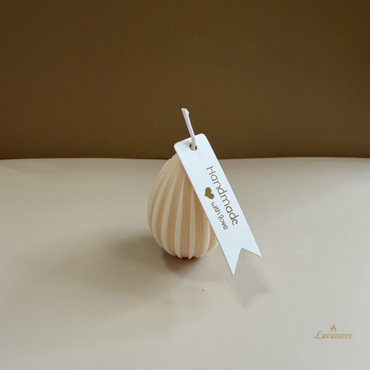 Handmade candle with a tag on a beige surface
