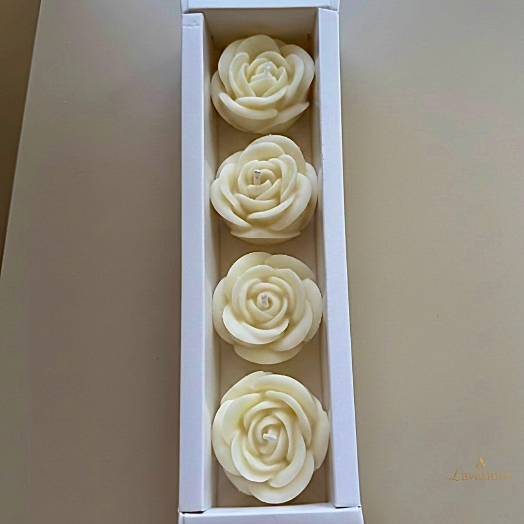 Four white rose-shaped candles in a box on a light gray background.Rose Gift Box sculptural rose soy wax candle set of four for luxury gifting