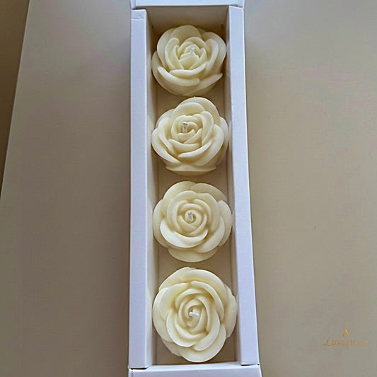 Four white rose-shaped candles in a box on a light gray background.Rose Gift Box sculptural rose soy wax candle set of four for luxury gifting