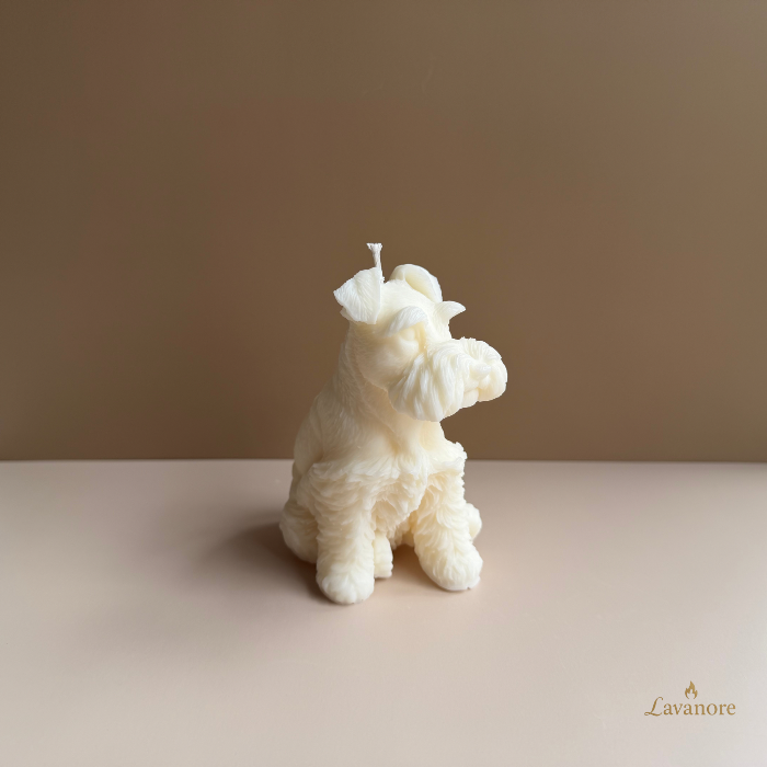 White dog-shaped candle on a beige surface with a plain background.Schnauzer sculptural soy wax candle designed for luxury gifting and modern home décor