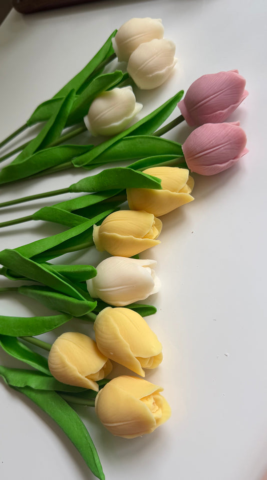 Decorative tulips in yellow, white, and pink on a white surface