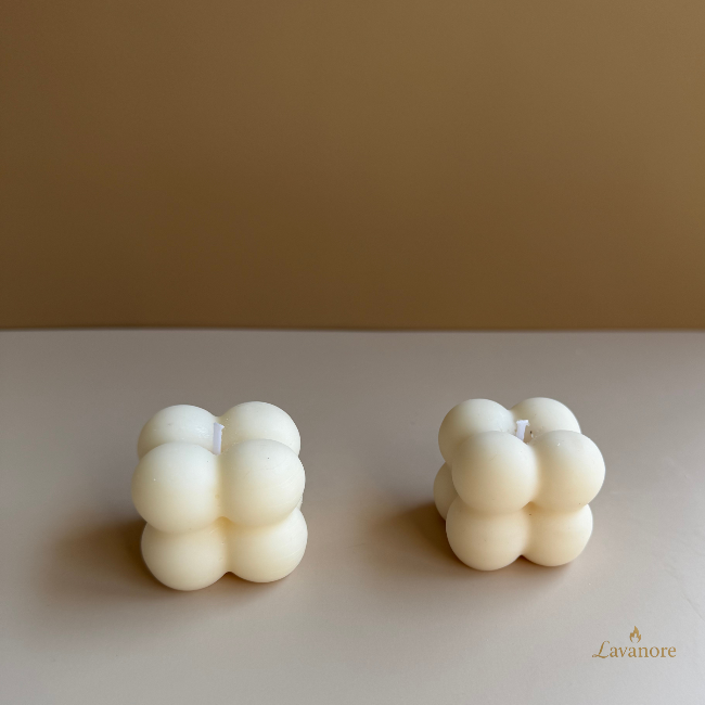 Two bubble-shaped candles on a beige surface with a brown background.Lumi Bubble sculptural bubble soy wax candle for luxury gifting and modern home décor