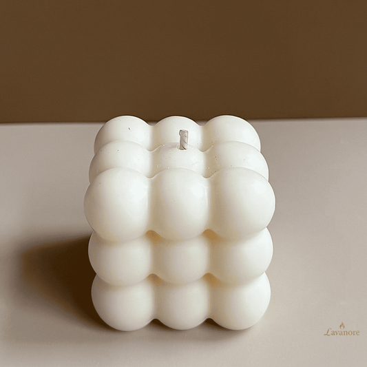 White textured candle on an open book with a blurred background, Bubble sculptural soy wax candle designed for modern décor and thoughtful gifting