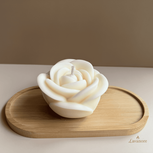 White rose-shaped candle on a wooden tray with a beige background. Rose Royale sculptural rose soy wax candle for luxury gifting and elegant home décor