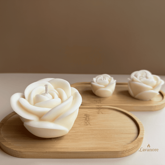Rose-shaped candles on wooden trays with a blurred background. Rose Royale sculptural rose soy wax candle for luxury gifting and elegant home décor