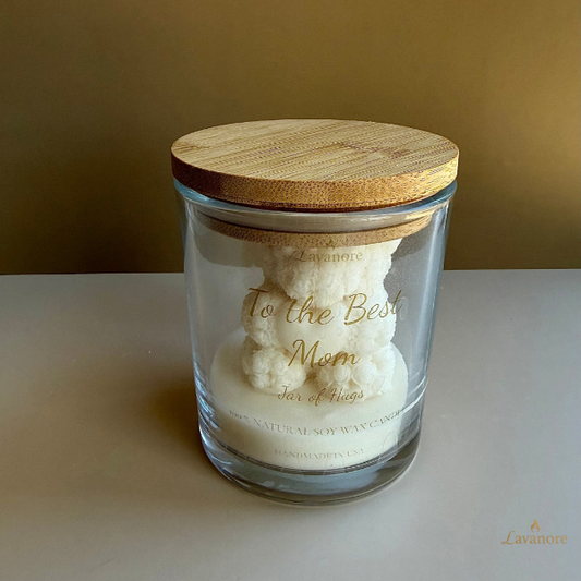 Glass candle jar with wooden lid and 'To the Best Mom' text on a beige.background.Jar of Hugs teddy bear sculptural soy wax candle in glass jar for luxury gifting